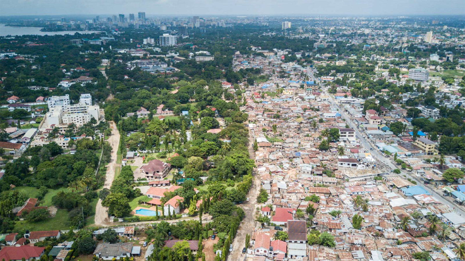 An aerial view of a cityscape full of homes, office buildings, and trees.