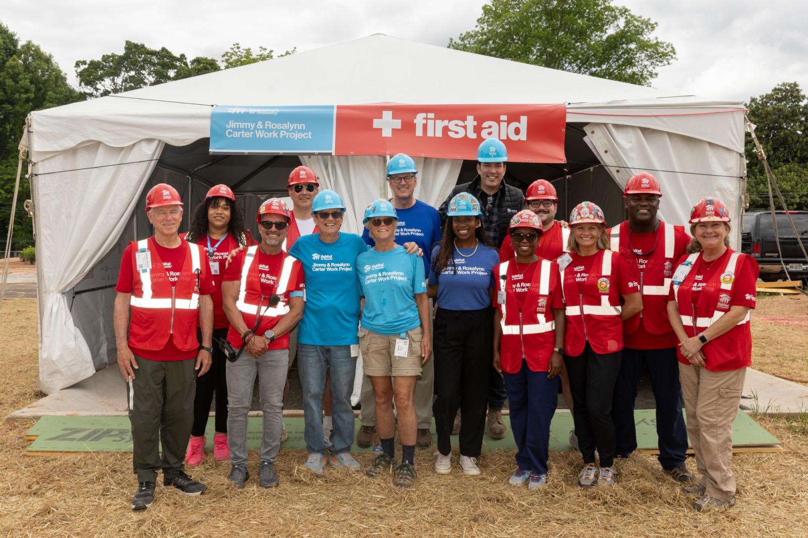 First aid volunteers posing as group in front of first aid tent.