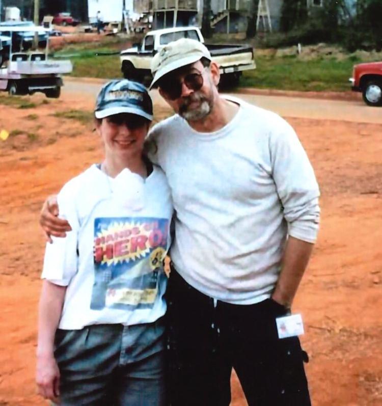 Old photo of a woman and her father posing together on a Habitat for Humanity worksite. 