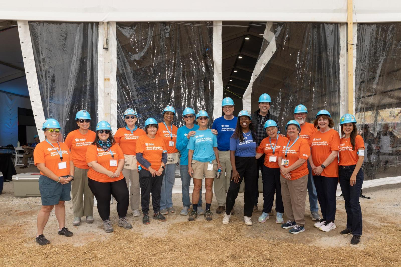 Hospitality volunteers posing for group photo in front of main Carter Work Project tent.
