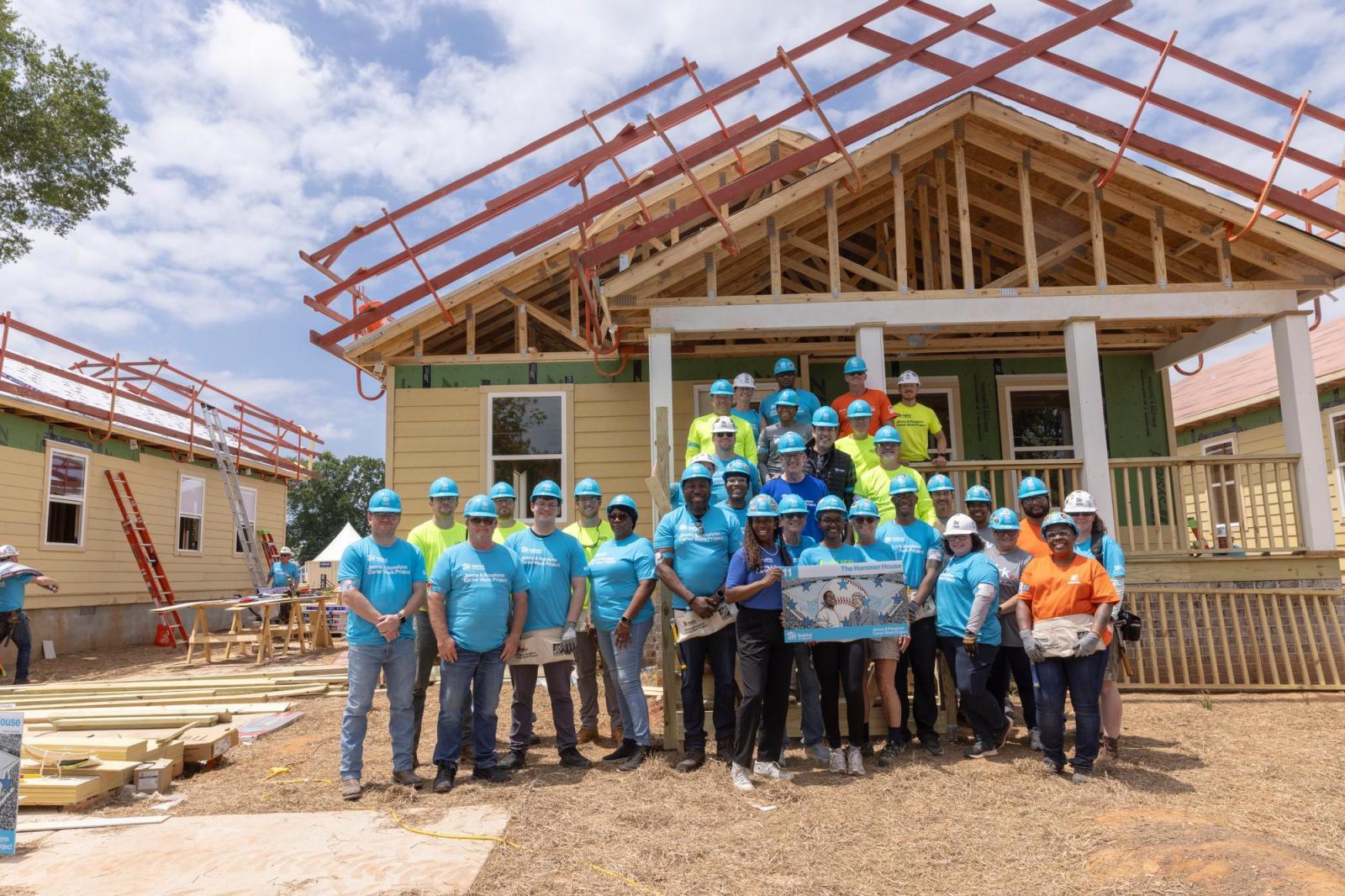 House 11 volunteers posing in front of house.