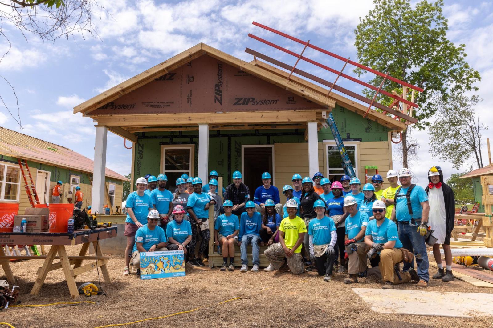House 13 volunteers posing in front of house.