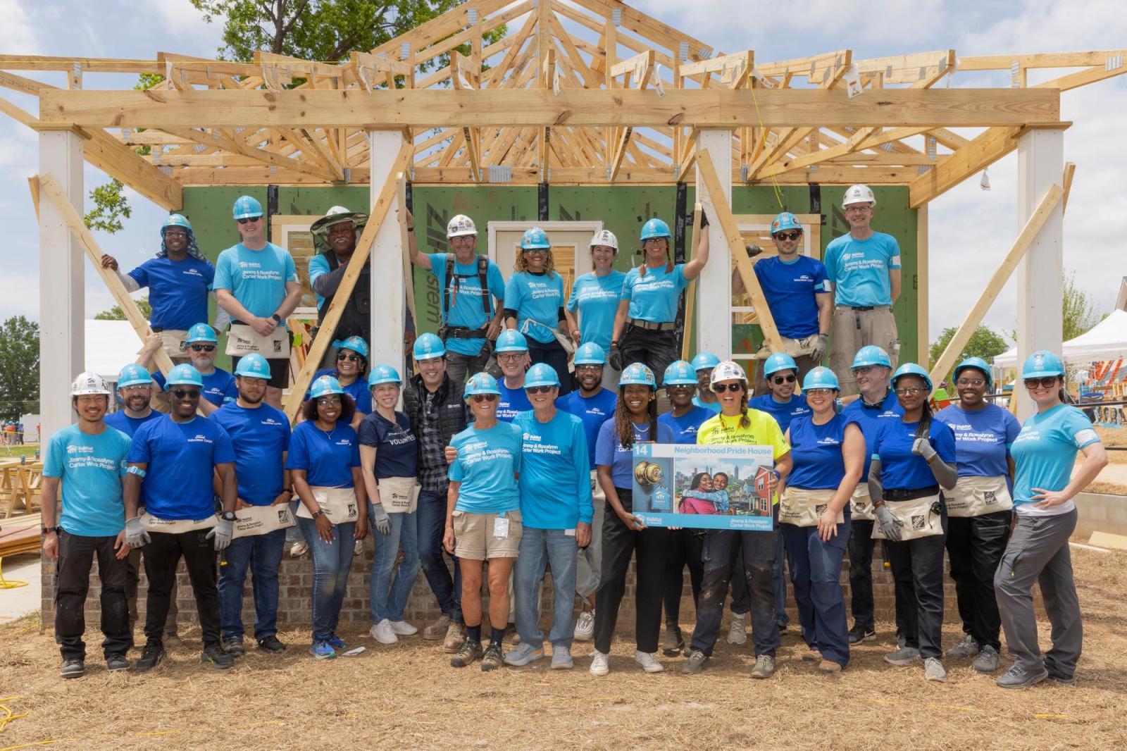 House 14 volunteers posing in front of house.