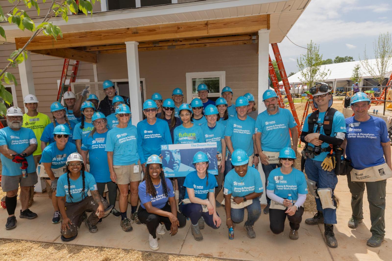 House 16 volunteers posing in front of house.