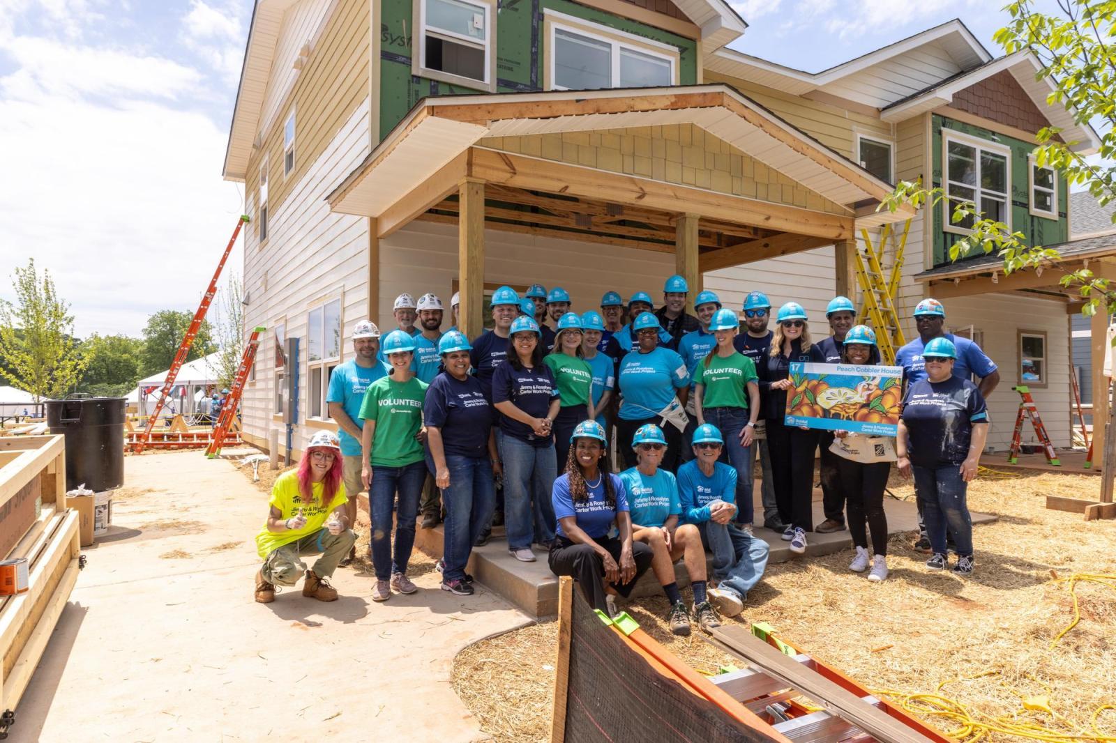 House 17 volunteers posing for group photo in front of house.