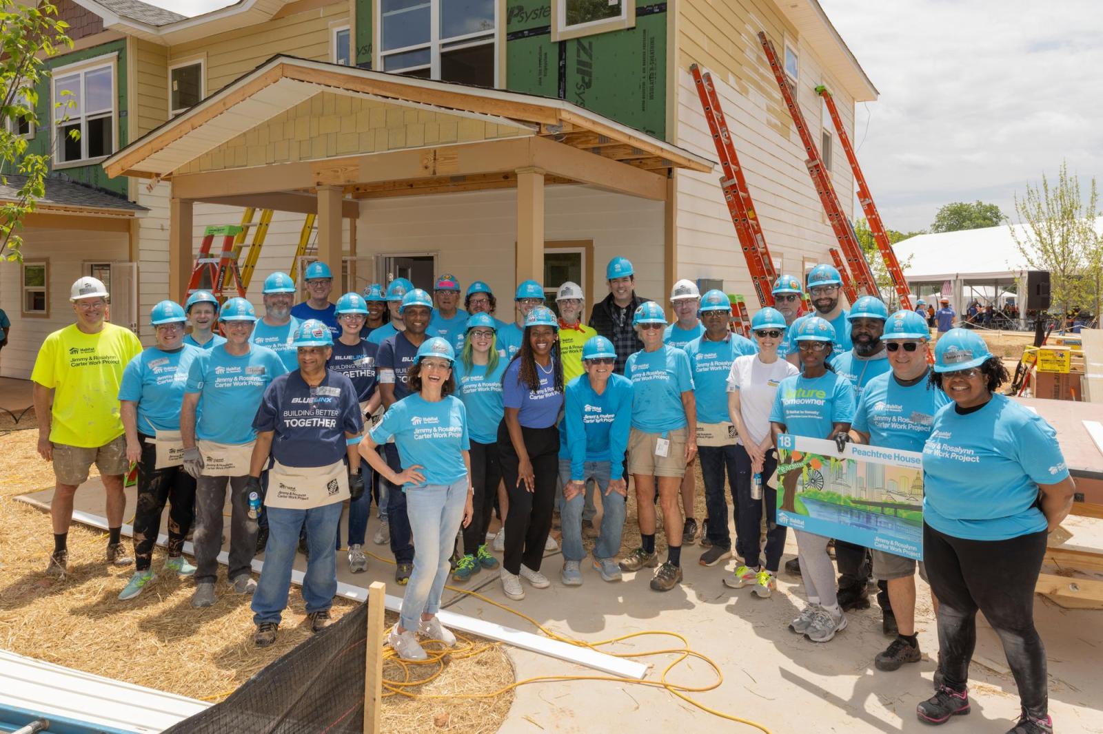 House 18 volunteers posing in front of house.