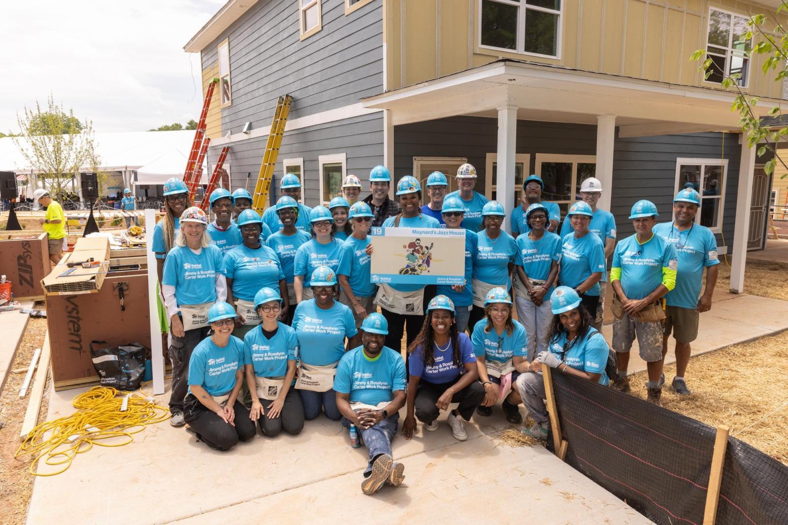 House 19 volunteers posing in front of house.