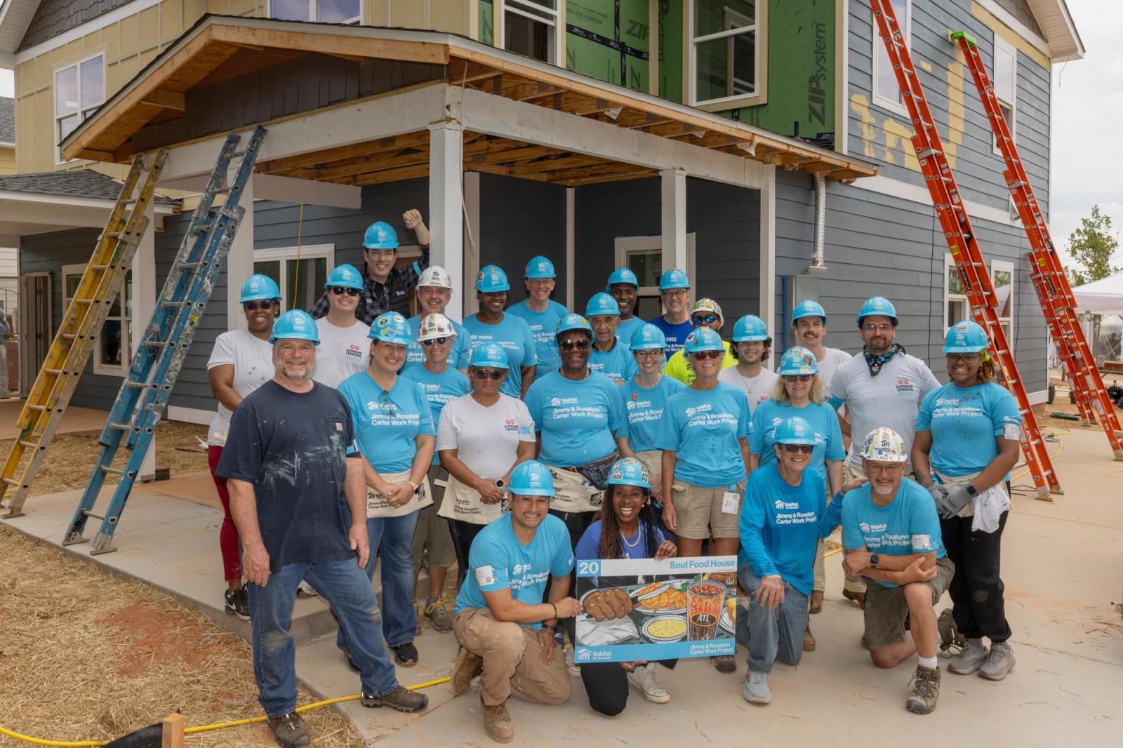 House 20 volunteers posing for group photo in front of house.