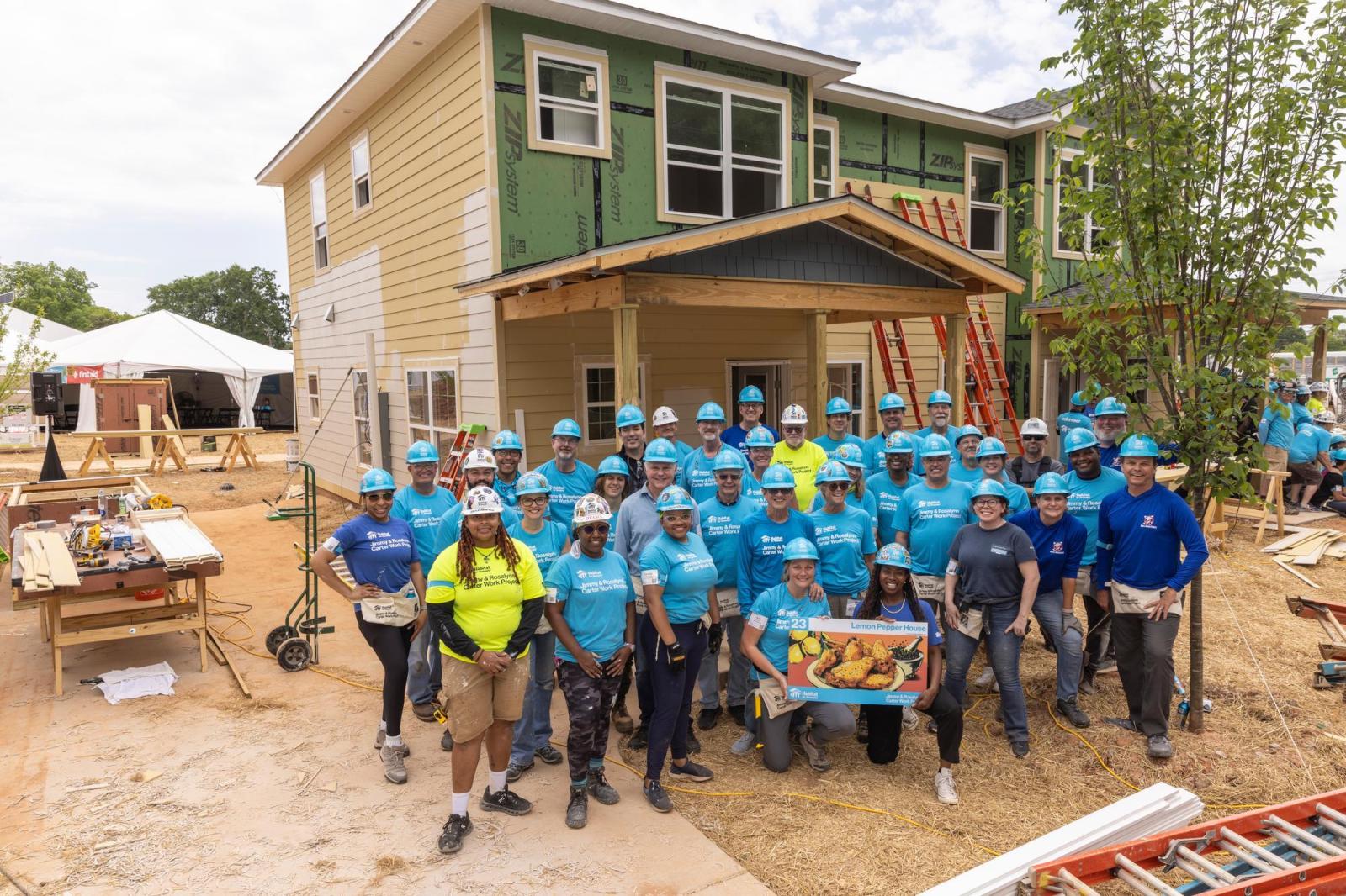 House 23 volunteers posing as group in front of house.