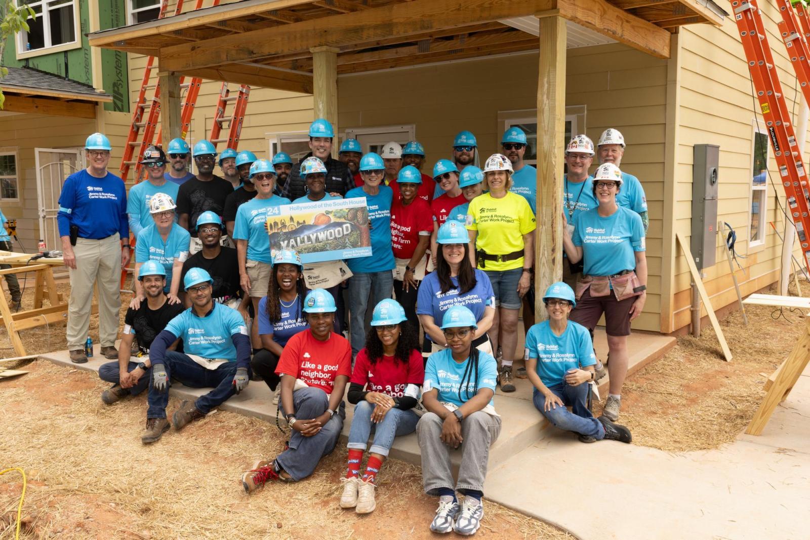Group of volunteers posing in front of house on site of 2026 Carter Work Project.