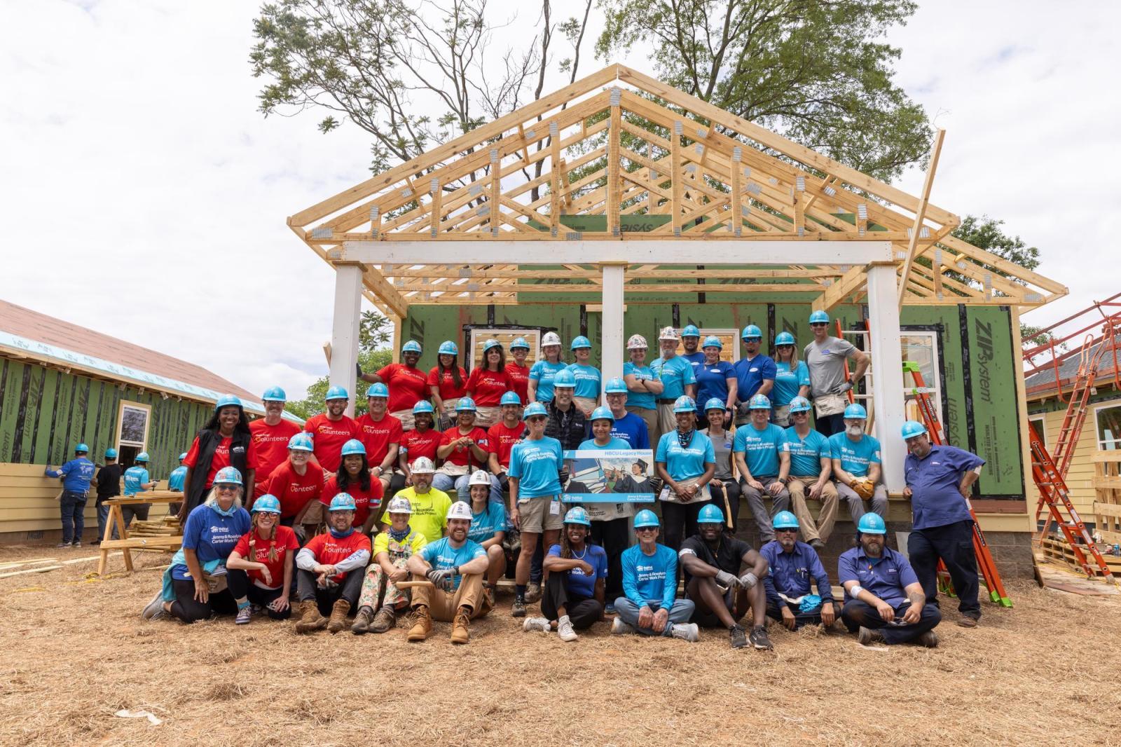 House 7 volunteers posing for group photo in front of house.