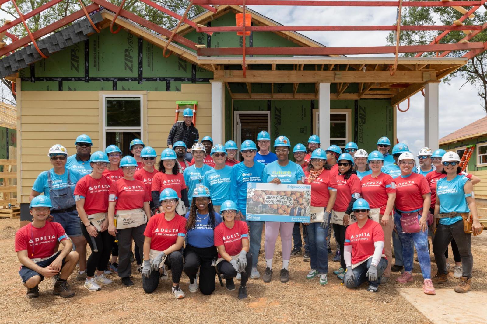 House 8 volunteers posing for group photo in front of house.