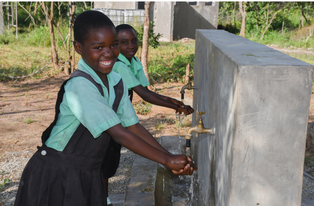 School children washing their hands at a hand washing station in school