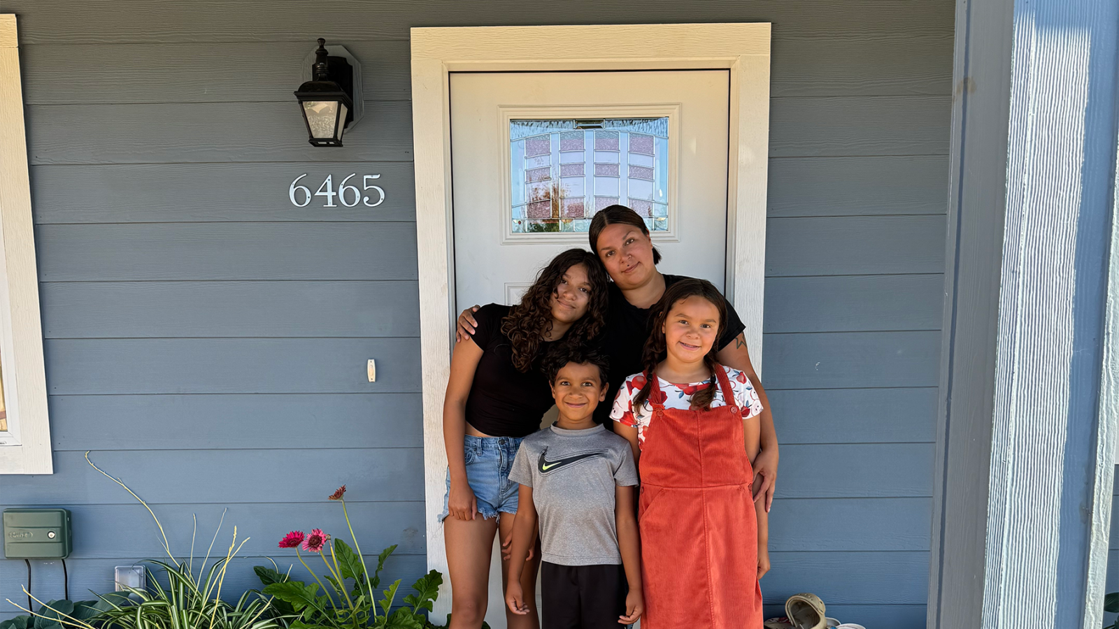Star and her children stand outside the front door of their new home.