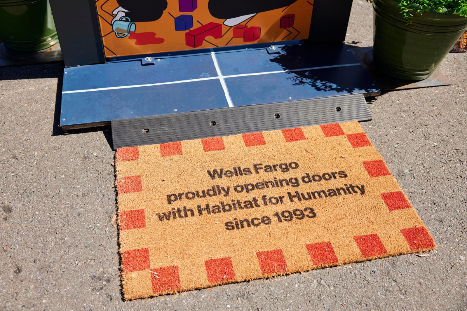 Red checkered door mat that says, "Wells Fargo proudly opening doors with Habitat for Humanity since 1993."