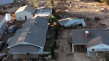 Photo of houses flooded and destroyed.  Debris and mud are everywhere.