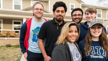 Six student volunteers standing in a group and smiling after participating in a Habitat volunteer opportunity.