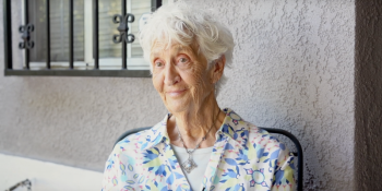 Older adult Rachel sits outside her home that has been updated with the Aging in Place program.