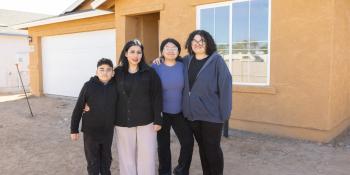 Family standing in front of house.