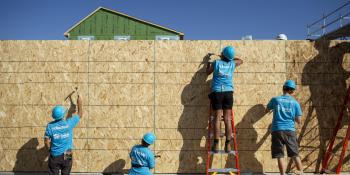 Volunteers work on an exterior wall during the Carter Work Project. 