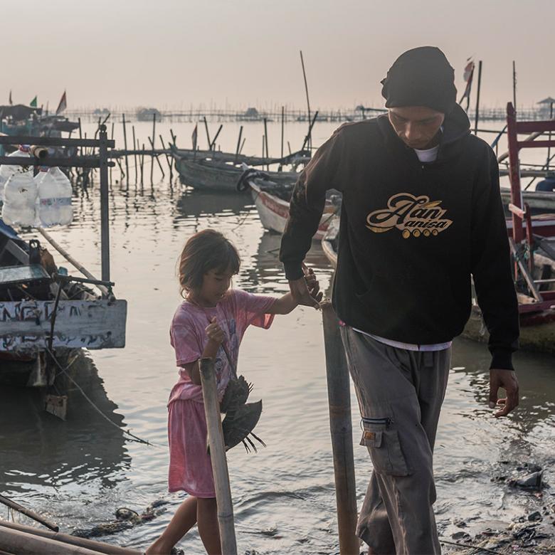 Ahmadi with his daughter in Tanjung Kait fishing village, Indonesia